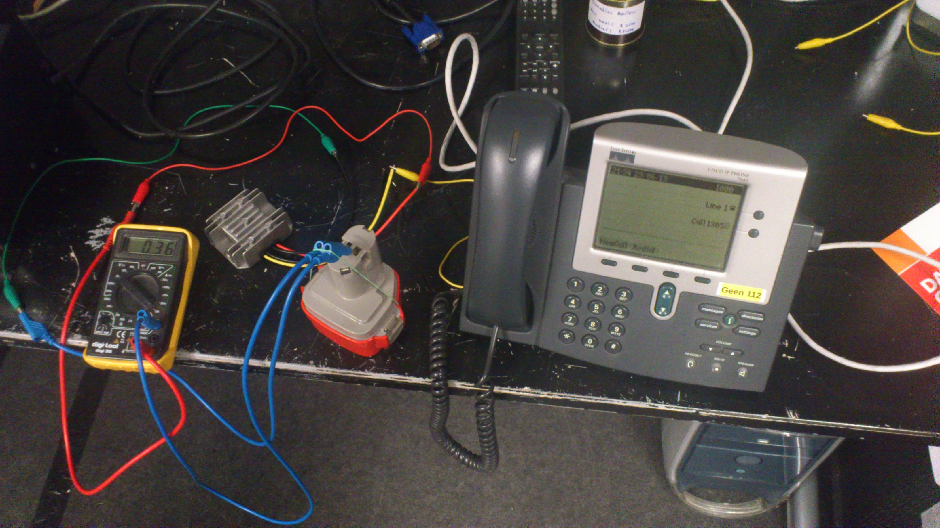 Cisco CP7940 running on a drill battery pack, shows 0.36A at approximately 12V